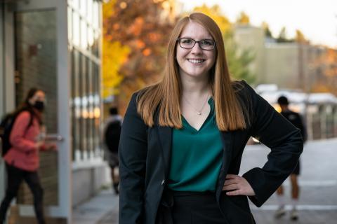 Student in professional attire outside during fall